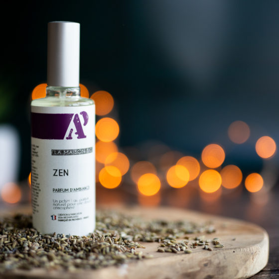 Bouteille de parfum Zen sur fond flou d'ampoules.