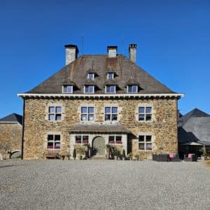 Maison en pierre avec porte d'entrée et fenêtres.